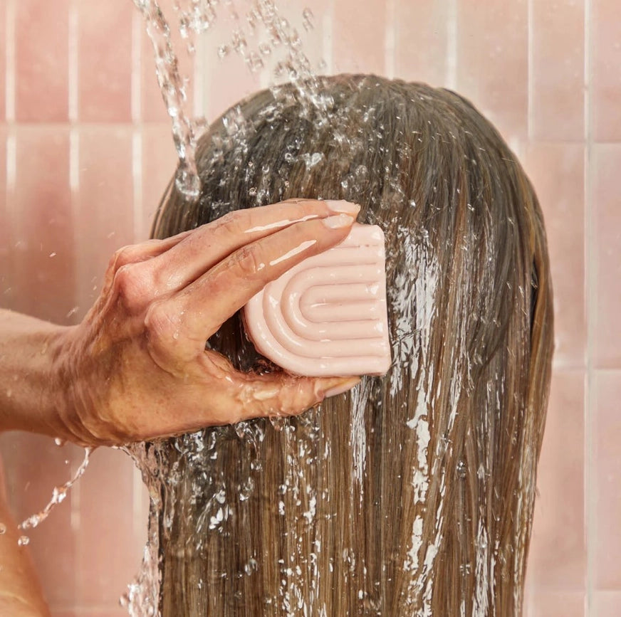 Person vasker hår med Kitsch shampoo & balsam bar, frizz-fri og sundt hår, zero waste
