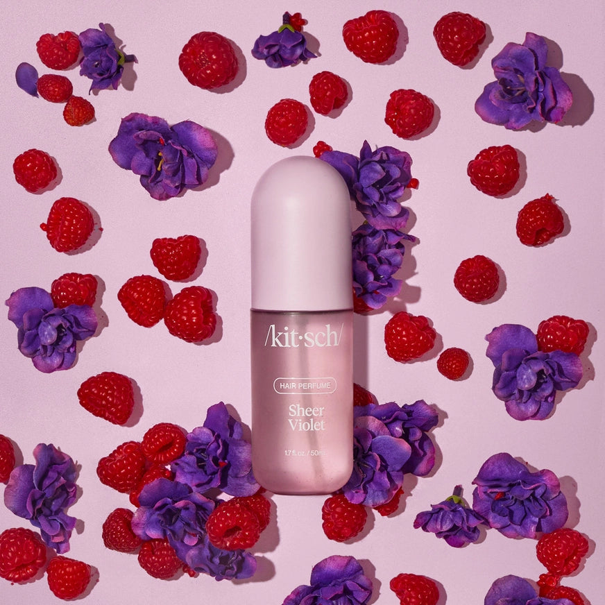 Kitsch hårparfume Sheer Violet med brombær og lilla blomster på lyserødt baggrund