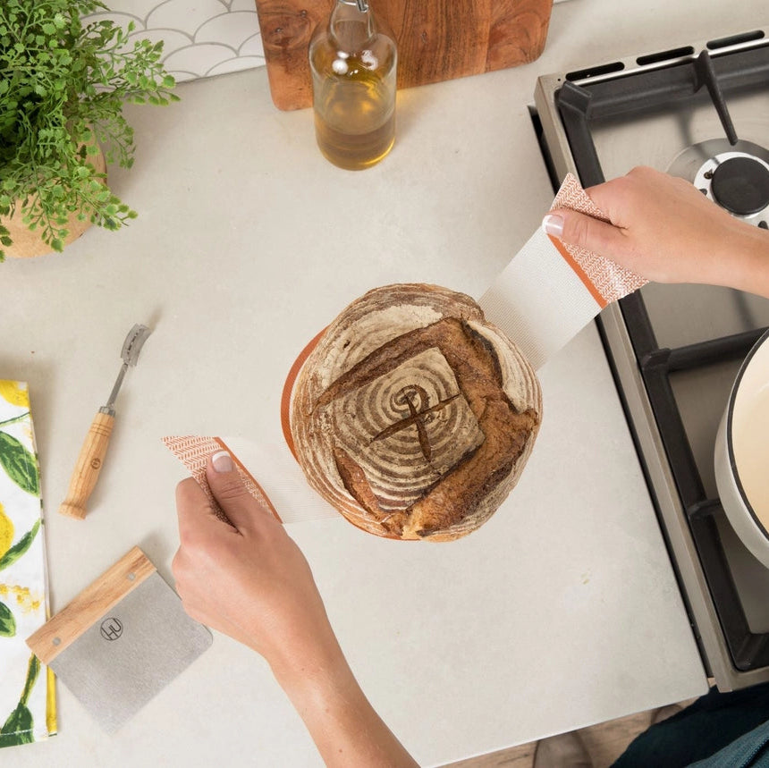Hånd der bruger bagemåtte til at flytte brød
