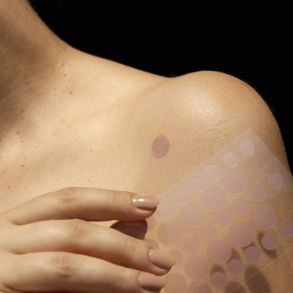 Person påføring af UV indikator plaster på huden, solbeskyttelse