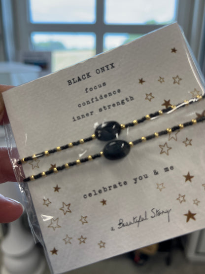 Sort onyx og guldperler armbånd