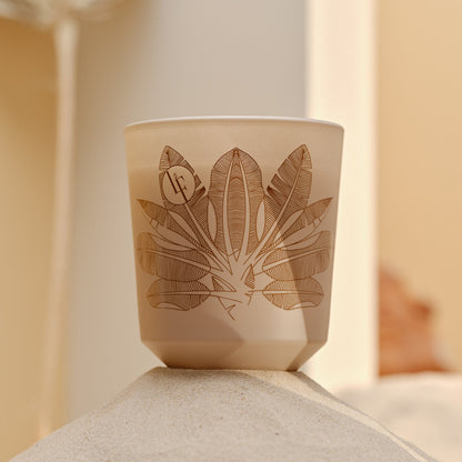 Nærbillede af duftlys med botanisk design, beige farvetema