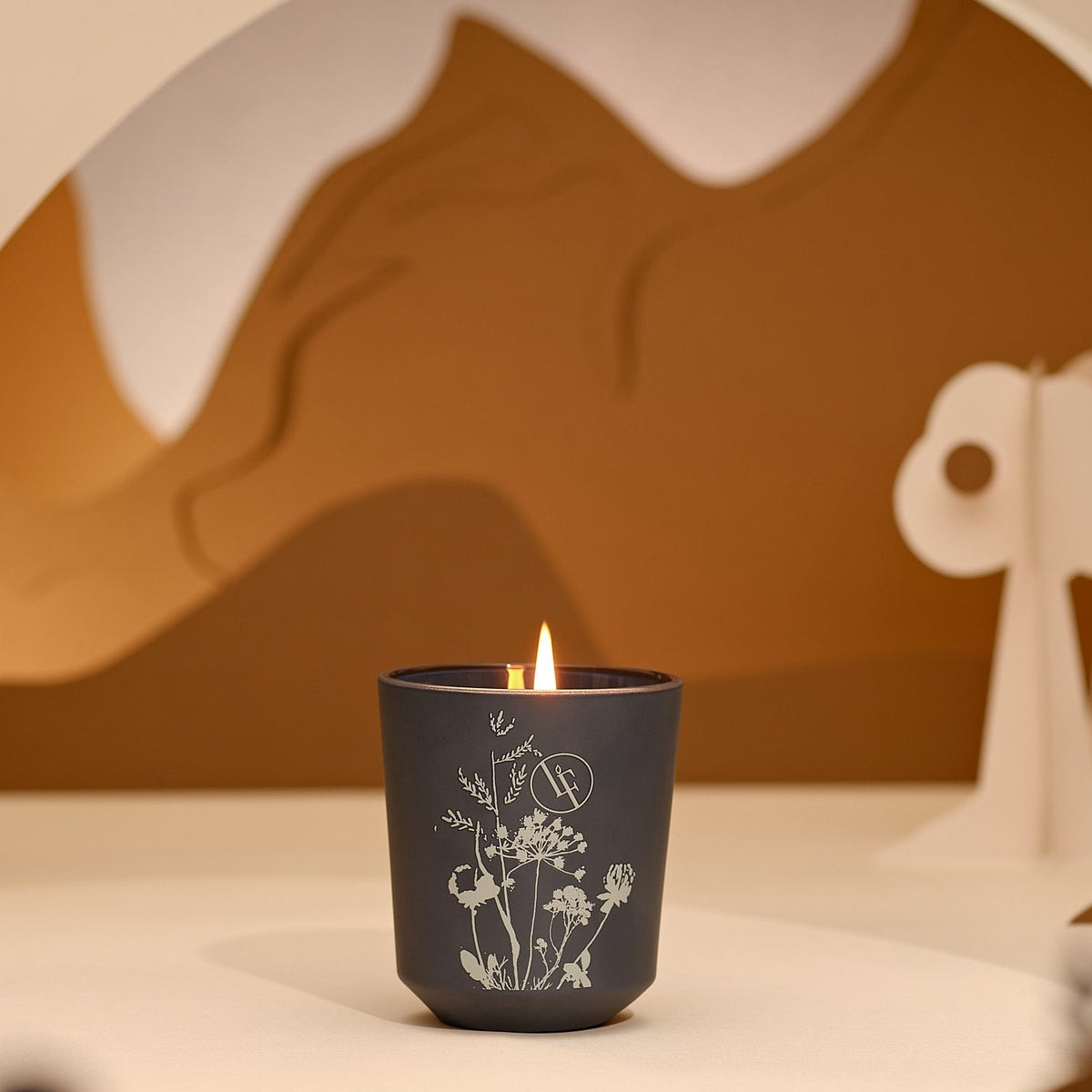 Sort duftlys med botanisk design i hjemmedekor