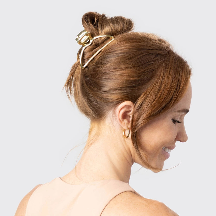 Guld hårklemme i open shape, stylet i håret