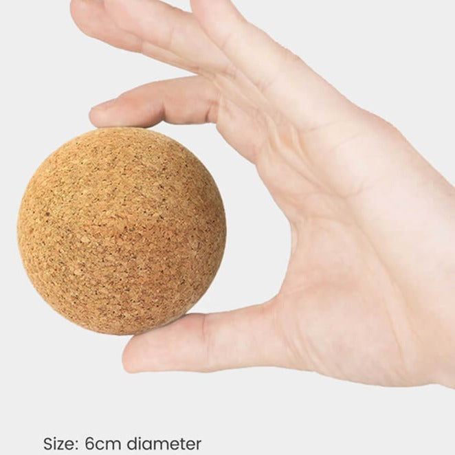 Hånd holder kork massagebold til selvpleje og triggerpunkt terapi
