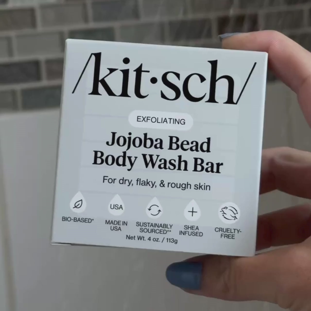 Kitsch jojoba body wash bar i hånden, nærbillede af emballage
