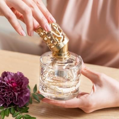 Person der fylder Maison Berger duftlampe med signaturduft i elegant glasflaske