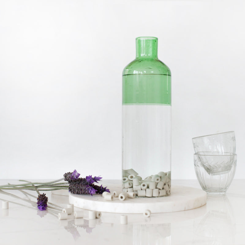 Kalkbekæmpelse med EM® keramiske perler i en grøn glasflaske